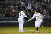 Oakland Athletics' Shea Langeliers (23) celebrates with third base coach Darren Bush (51) after hitting a solo home run against the New York Yankees during the sixth inning of a baseball game in Oakland, Calif., Thursday, Aug. 25, 2022. (AP Photo/Godofredo A. Vásquez)
