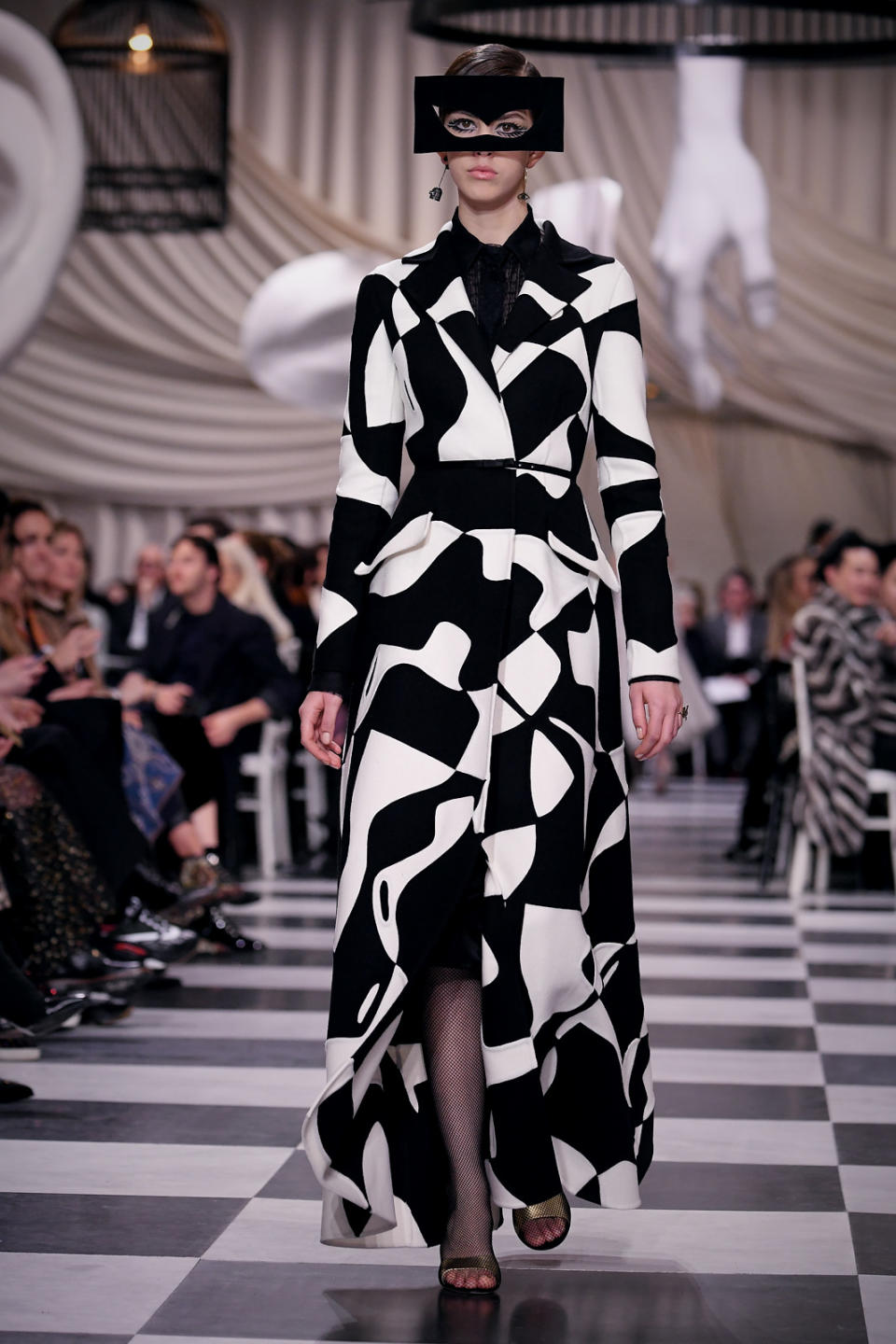 <p>A model wears a black and white “puzzle” coat and cut-out mask from the Dior Haute Couture SS18 collection. (Photo: Getty) </p>