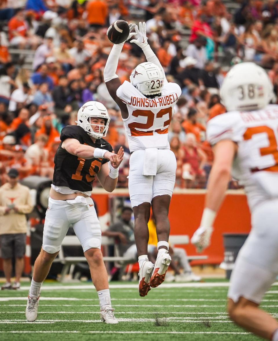 Texas defensive back Jordon Johnson-Rubell, center, just misses an interception of a pass thrown by quarterback Cole Lourd during the fourth quarter of Saturday's UT Orange-White spring game at Royal-Memorial Stadium.