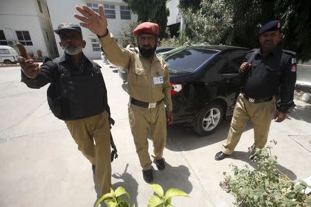 Police officers stop media from going near the car of Abdul Rashid Godil, a member of the Muttahida Qaumi Movement (MQM) after he was shot, at a hospital in Karachi, Pakistan, August 18, 2015. REUTERS/Athar Hussain