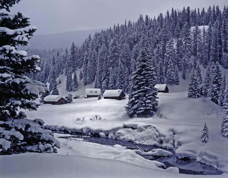 snowy log cabins in ethereal moonlight