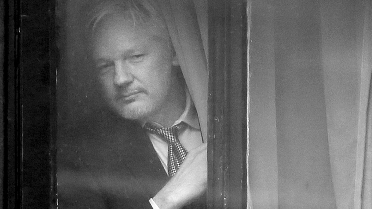 Wikileaks founder Julian Assange appears at the window before speaking on the balcony of the Ecuadorean Embassy in London on Feb. 5, 2016. (Kirsty Wigglesworth/AP)