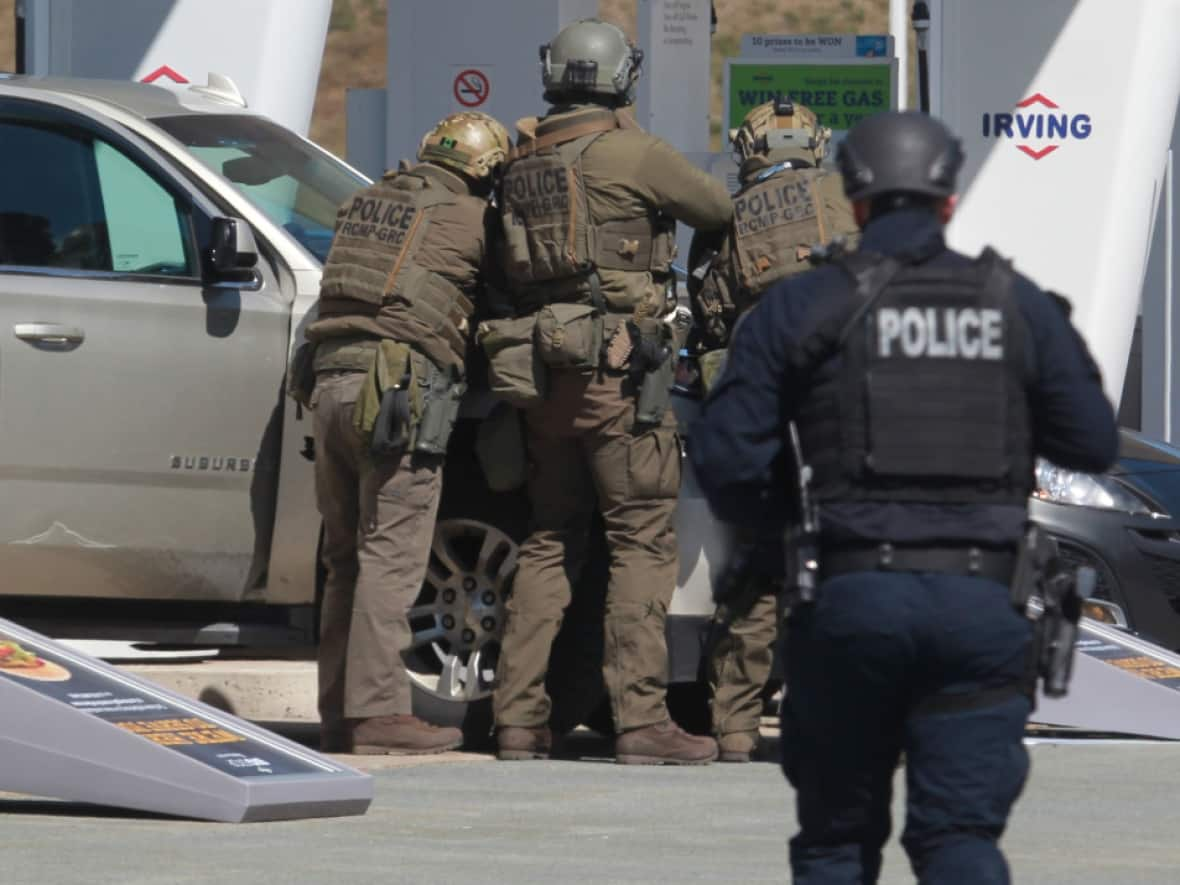 RCMP officers prepare to take a person into custody at a gas station in Enfield, N.S. on Sunday April 19, 2020. The gunman who killed 22 people was fatally shot by police at the gas station. (Tim Krochak/The Canadian Press - image credit)