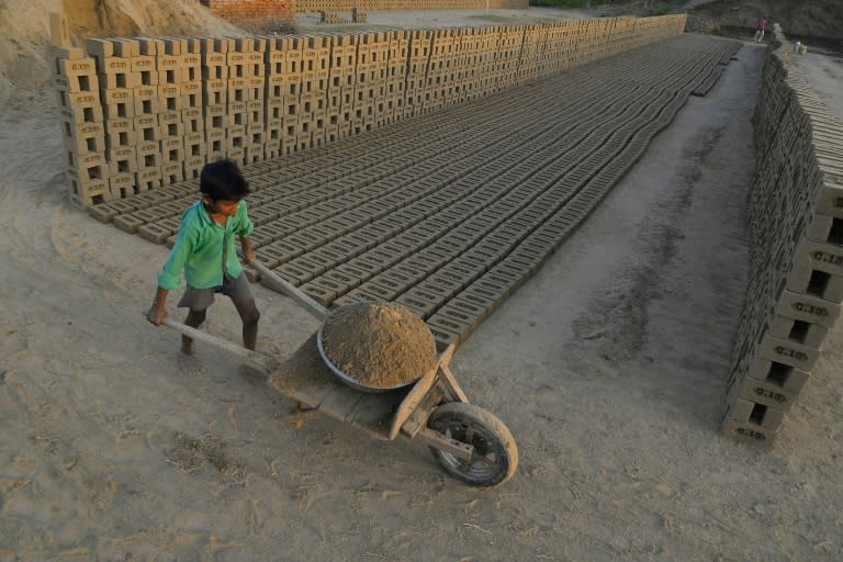 This photograph taken on September 18, 2017 shows an Indian boy working at a brick kiln on the outskirts of Jalandhar on September 18, 2017