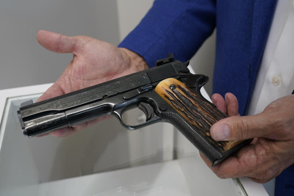 Brian Witherell displays a Colt .45-caliber pistol that once belonged to mob boss Al Capone, at Witherell's Auction House in Sacramento, Calif., Wednesday, Aug. 25, 2021. The pistol is among the 174 family heirlooms that will be up for sale at an Oct. 8 auction titled "A Century of Notoriety: The Estate of Al Capone," that will be held by Witherell's. (AP Photo/Rich Pedroncelli)
