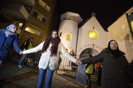 Muslim women join hands to form a human shield as they stand outside a synagogue in Oslo February 21, 2015. REUTERS/Hakon Mosvold Larsen/NTB Scanpix