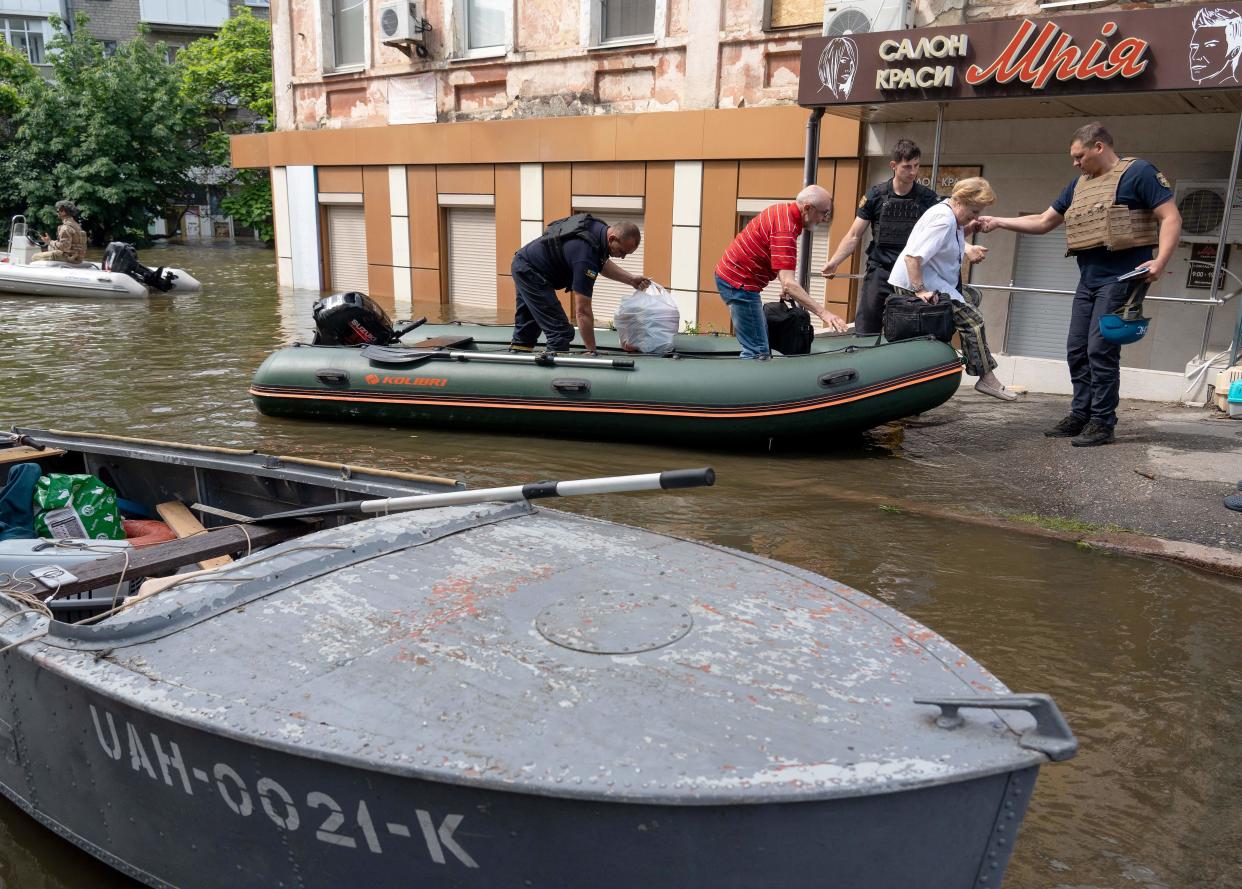 Ukrainian security forces help unload local residents from a boat during an evacuation from a flooded area in Kherson, June 8, 2023, following the destruction of the Kakhovka hydroelectric power plant dam. / Credit: ALEKSEY FILIPPOV/AFP/Getty