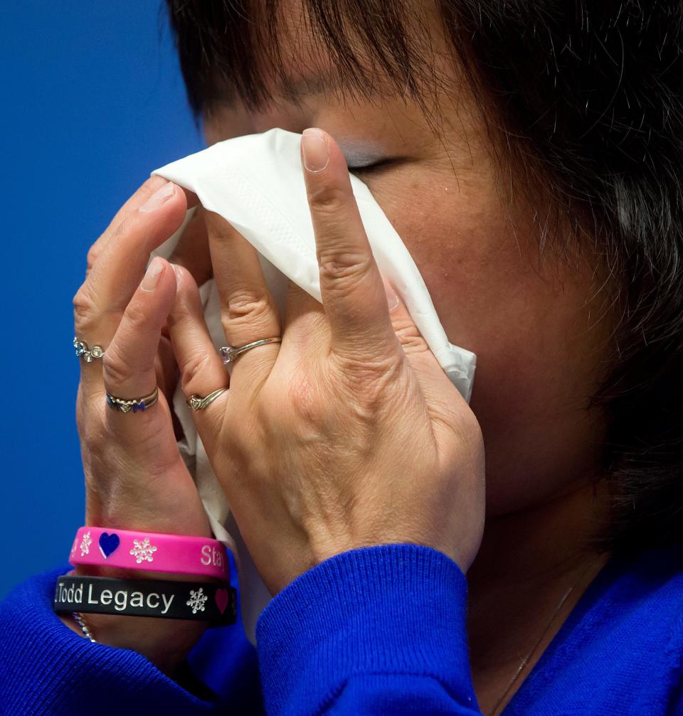 Carol Todd wears a bracelet in memory of her daughter as she wipes away tears while attending a Royal Canadian Mounted Police news conference in Surrey, British Columbia, on Thursday, April 17, 2014. A 35-year-old man alleged to be involved with the online extortion of Todd's 15-year-old daughter, who committed suicide in 2012, has been arrested in the Netherlands. (AP Photo/The Canadian Press, Darryl Dyck)