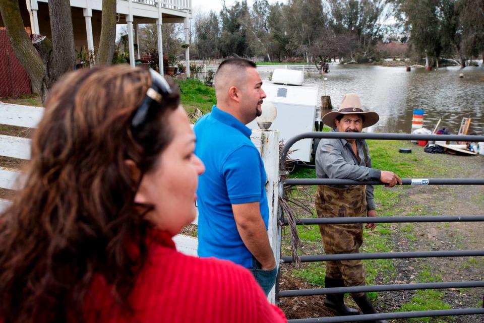 Alberto Bolanos, right, talks with his neighbors about the rising water from the Tuolumne River on Vivian Road in south west Modesto, Calif., on Saturday, Feb. 18, 2017.