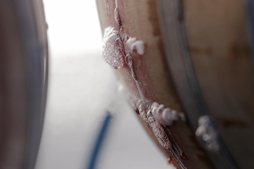 In this photo taken Thursday, Nov. 21, 2019, remnants of a red wine bubbles out of the seams of an oak barrel being hydrated with steam to seal it before new wine is added at Patterson Cellars winery in Woodinville, Wash. From less than 20 wineries in 1981, the Washington wine industry has grown to more than 1,000 this year. And the growth is likely to continue. (AP Photo/Elaine Thompson)