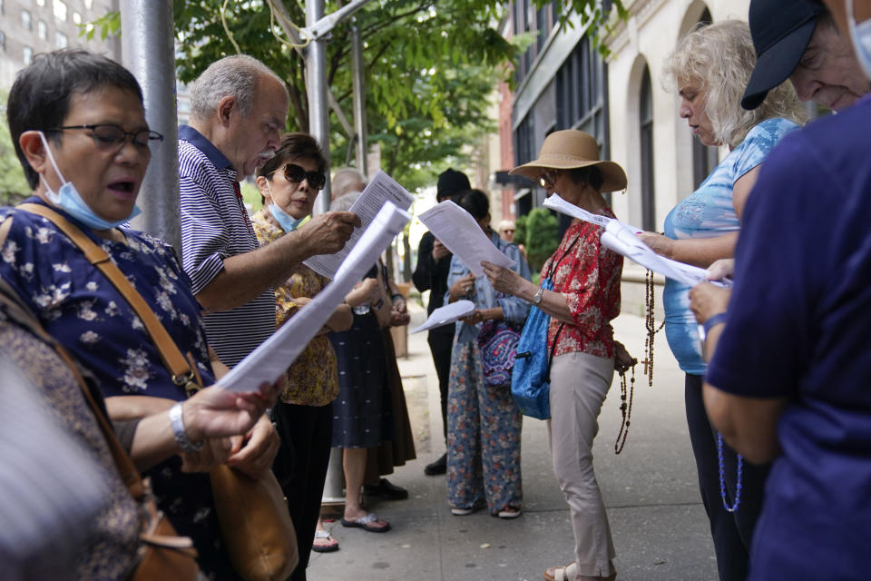 A group of Catholics pray outside a public library during a Drag Story Hour in New York, Friday, June 17, 2022. The "rosary rally" was in protest of the drag story time. (AP Photo/Seth Wenig)