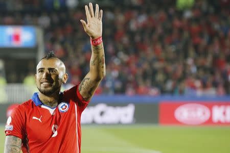 Chile's Arturo Vidal waves ahead of the first round Copa America 2015 soccer match against Bolivia at the National Stadium in Santiago, Chile, June 19, 2015. REUTERS/Henry Romero