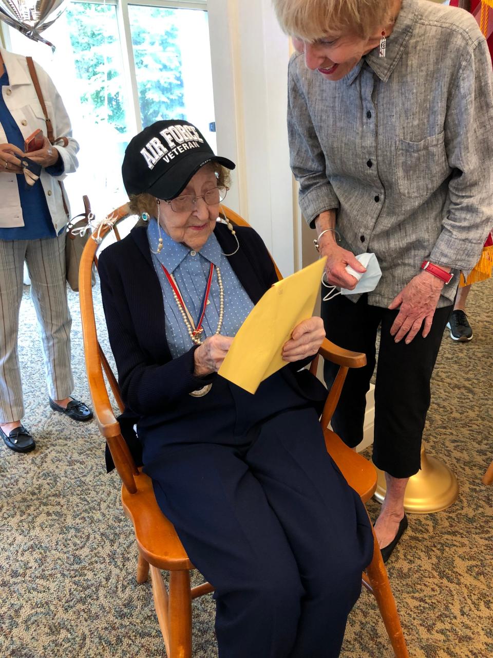 Wearing her new Air Force Veterans hat, Gladys Laughland opens a gift on her 104th birthday at Wingate Residences at Silver Lake in Kingston.