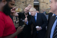 Britain's Prime Minister Boris Johnson poses for a selfie with a member of the publicduring a visit to Doncaster Market, in Doncaster, Northern England, Friday Sept. 13, 2019. Johnson will meet with European Commission president Jean-Claude Juncker for Brexit talks Monday in Luxembourg. The Brexit negotiations have produced few signs of progress as the Oct. 31 deadline for Britain’s departure from the European Union bloc nears. ( AP Photo/Jon Super)