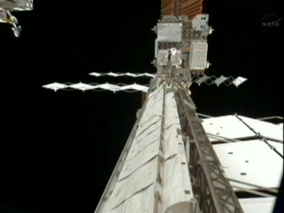 A spare radiator in the process of deploying (right). Spacewalking astronauts Suni Williams and Aki Hoshide deployed the radiator on Nov. 1, 2012 in an attempt to isolate an ammonia leak in the space station's cooling system.