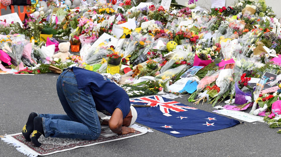 A man prays in front of the floral tributes left for the victims of the mosque attacks. Source: AAP