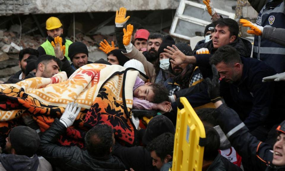 Rescuers carry out a girl from a collapsed building.