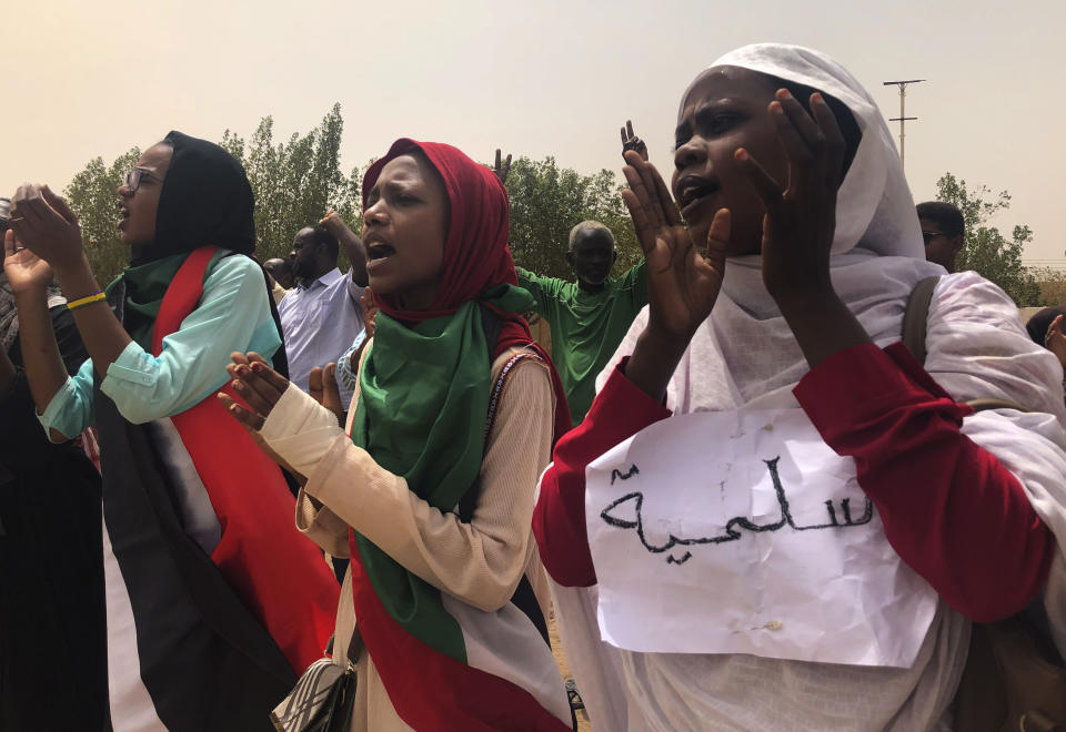 FILE - In this June 30, 2019 file photo, Sudanese protesters chant slogans as they march during a demonstration against the ruling military council, in Khartoum, Sudan. The sign in Arabic reads, "peace." Sudan’s uprising has ushered in a new era both for the nation and for Sudanese women after three decades of autocratic rule by Omar al-Bashir. Sudanese women played a pivotal role in the protests that brought down al-Bashir, and under a joint military-civilian council in power now, they hope for more freedom and equality, and seek to overturn many of the restrictive Islamic laws from the previous era. (AP Photo/Hussein Malla, File)