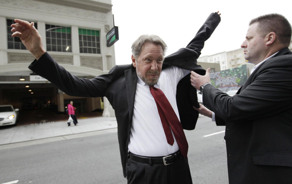 Oracle CEO Larry Ellison, left, puts on his suit as arrives for a court appearance at a federal building in San Francisco, Tuesday, April 17, 2012. Oracle intends to rely heavily on Google's own internal emails to prove Google's top executives knew they were stealing a popular piece of technology to build the Android software that now powers more than 300 million smart phones and tablet computers. (AP Photo/Paul Sakuma)