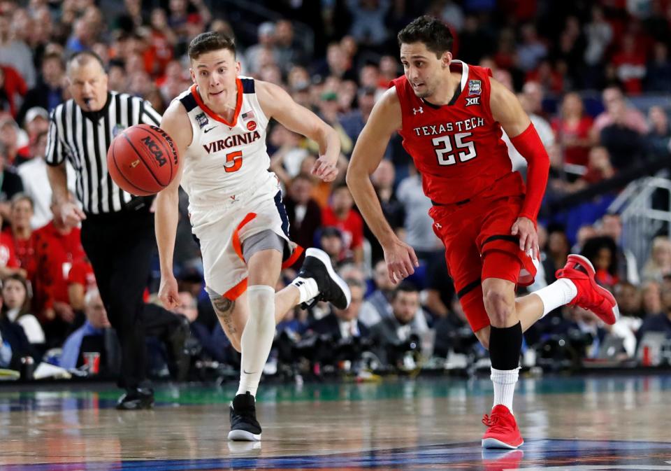 Virginia's Kyle Guy (5) and Texas Tech's Davide Moretti (25) chase a loose ball during the overtime in the championship of the Final Four NCAA college basketball tournament, Monday, April 8, 2019, in Minneapolis. (AP Photo/Jeff Roberson)