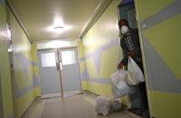 Sam, a resident in Dennison Point tower block receives food donations at his front door from a local food bank, as the spread of the coronavirus disease (COVID-19) continues, in east London