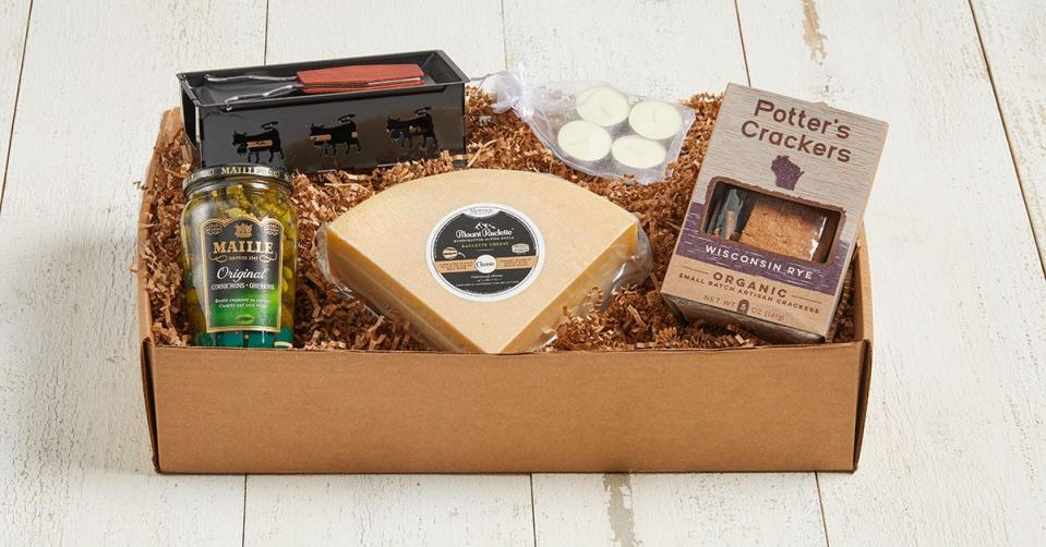 A gift box by Wisconsin cheesemaker Alpinage Artisan Cheese adds a tea-light-fueled melter, crackers and pickles to 1 pound, a quarter wheel or half wheel of raclette that's aged in Oak Creek.