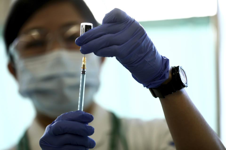 A medical worker fills a syringe with a dose of the Pfizer-BioNTech COVID-19 vaccine at Tokyo Medical Center in Tokyo Wednesday, Feb. 17, 2021. Japan's first coronavirus shots were given to health workers Wednesday, beginning a vaccination campaign considered crucial to holding the already delayed Tokyo Olympics. (Behrouz Mehri/Pool Photo via AP)