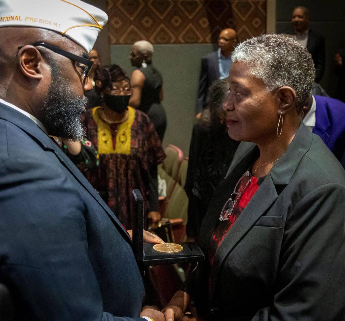 James T. Averhart, national president of the Montford Point Marine Association, presents Pamela Y. Williams, with a medal honoring her father, Cpl. Moses Williams, during a Congressional Gold Medal Ceremony held at the African American Research Library and Cultural Center in Fort Lauderdale Monday, Feb. 6, 2023. Williams received a posthumous medal for her father for his time as a Montford Point Marine.