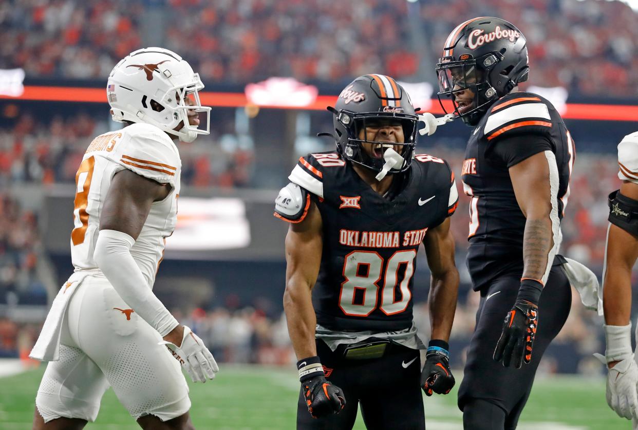 Oklahoma State's Brennan Presley (80) celebrates his touchdown pass with Rashod Owens (10) next to Texas's Terrance Brooks (8) in the first half of the Big 12 Football Championship game between the Oklahoma State University Cowboys and the Texas Longhorns at the AT&T Stadium in Arlington, Texas, Saturday, Dec. 2, 2023.