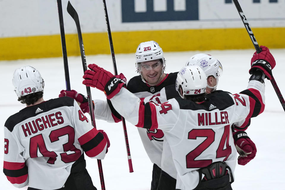 New Jersey Devils center Michael McLeod (20) celebrates with, from left, defenseman Luke Hughes (43), defenseman Colin Miller (24) and center Curtis Lazar (42) after scoring a goal against the Washington Capitals during the third period of an NHL hockey game in Washington, Wednesday, Jan. 3, 2024. (AP Photo/Susan Walsh)