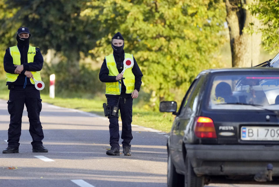 Polish police officers stop cars going in and out of an area along the border with Belarus where a state of emergency is in place, in Krynki, Poland, on Wednesday, Sept. 29, 2021. After enduring a decade of war in Syria, Boshra al-Moallem and her two sisters seized their chance to flee, but the journey proved terrifying and nearly deadly. Al-Moallem, originally from Homs but who displaced to Damascus by the war, is one of thousands of people who have traveled to Belarus in recent weeks and then found herself helped to cross the border with the help of Belarusian guards, something the EU considers a form of “hybrid war” waged against the bloc with the use of human lives. (AP Photo/Czarek Sokolowski)