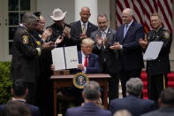 President Donald Trump holds up an executive order on police reform after signing it in the Rose Garden of the White House, Tuesday, June 16, 2020, in Washington. (AP Photo/Evan Vucci)