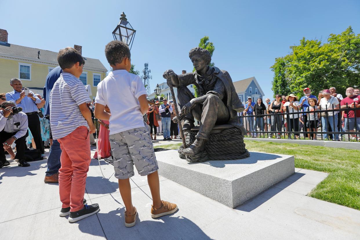 Children take a closer look at the Frederick Douglass statue, which was unveiled during the Abolition Row Park dedication in New Bedford.