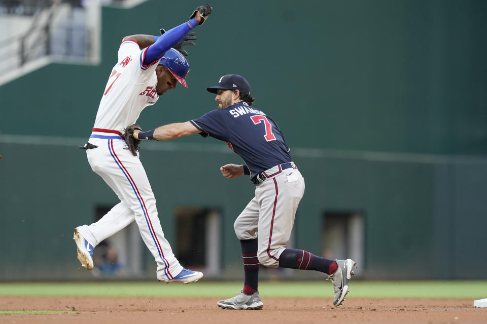 Atlanta Braves shortstop Dansby Swanson (7) tags out Texas Rangers' Andy Ibanez at second base during the second inning of a baseball game in Arlington, Texas, Saturday, April 30, 2022. Zach Reks was safe at first. (AP Photo/LM Otero)