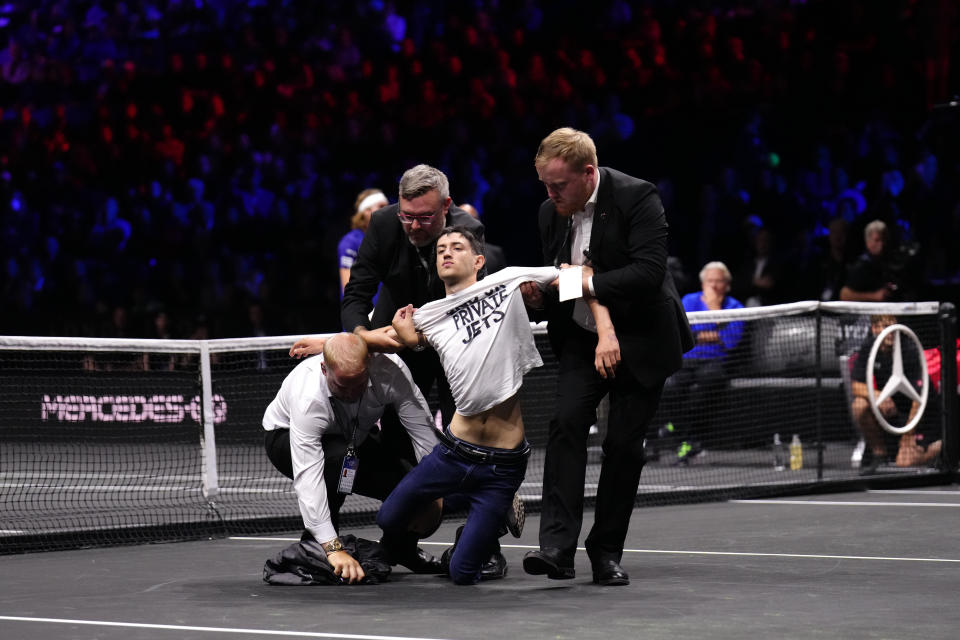 Stewards, pictured here removing a protester after he set fire to the court at the Laver Cup.