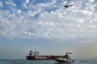 A boat of the Iranian Revolutionary Guard sails next to Stena Impero at Bandar Abbas port