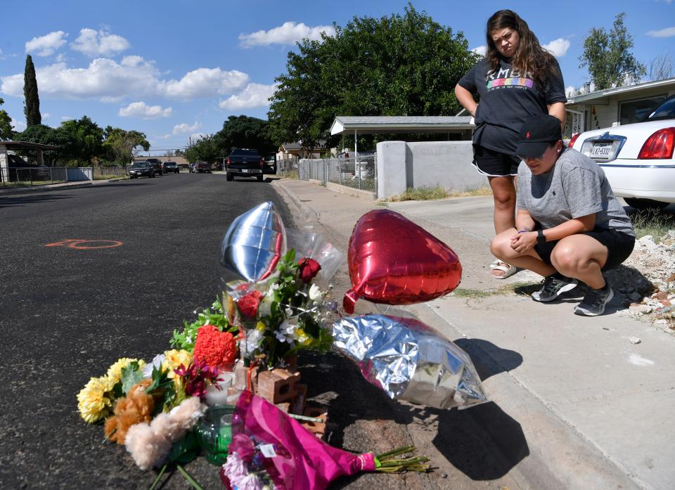 Ashley Salazar, right, and Alyssa Baeza, both of Midland, Texas, pray over a memorial to slain postal worker Mary Granados in Odessa on Sept. 2, 2019. The letter carrier was one of seven killed by Seth Aaron Ator, 36, who went on a shooting spree and struck nearly two dozen people with gunfire.