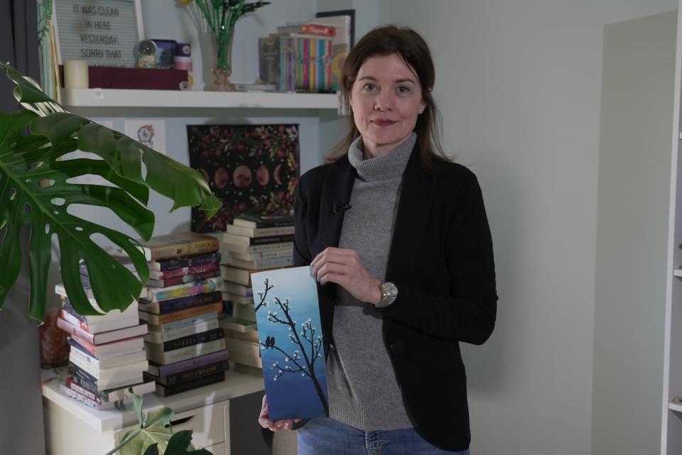 Ontario parent Kelly Dynes stands in the bedroom of her 17-year-old holding artwork created by he daughter. Dynes says social media was a factor that exacerbated her teen's disordered eating, which derailed her schooling.