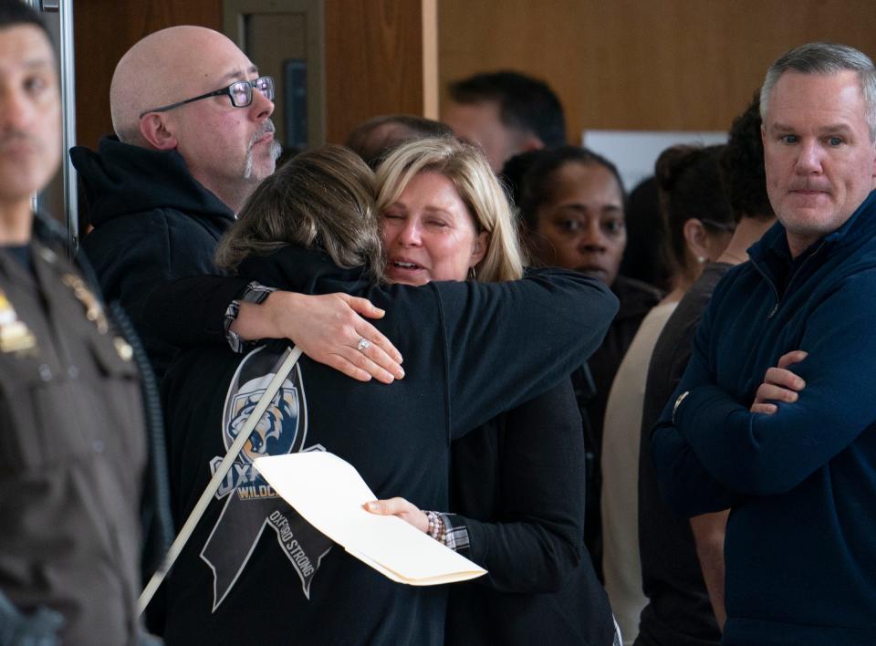 Oxford High School teacher Molly Darnell (facing) cries as she receives a hug in the hallway after giving a witness statement in the courtroom of Judge Kwame Rowe as Ethan Crumbley, the Oxford High School shooter is set to be sentenced at the Oakland County Courthouse Friday, Dec. 08, 2023.