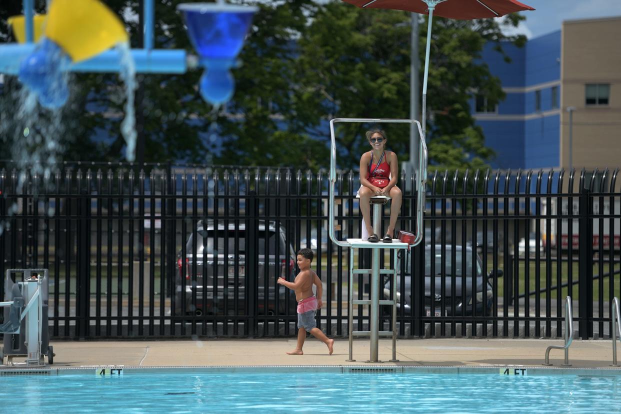 A lifeguard smiles as a child walks by at the Crompton Park Pool in a 2022 file photo.