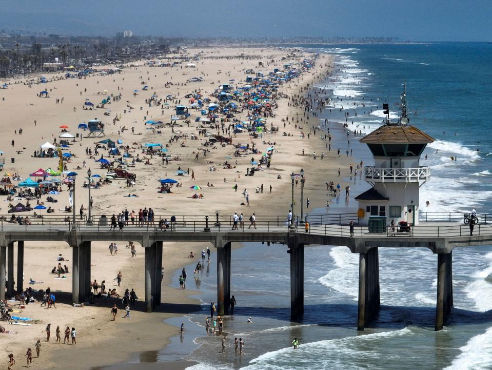 Beachgoers flock to the beach south of the pier in Huntington Beach, Calif., on June 30, 2023.