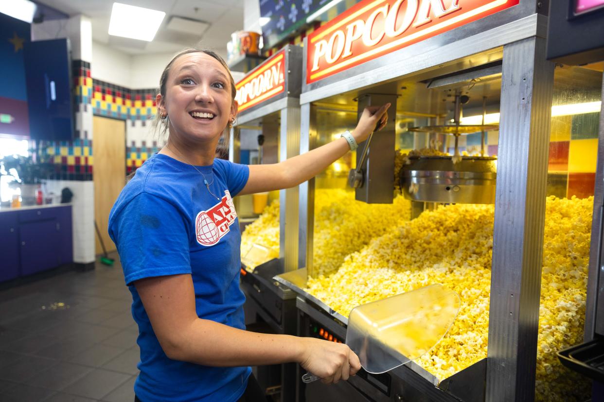 High school senior Natalia Freitas makes popcorn for customers on a Saturday morning. Freitas, a 3-year veteran of Atlas Cinemas Mayfield location, has been helping with the grand opening of the new theater in Aurora’s Barrington Town Center shopping center.