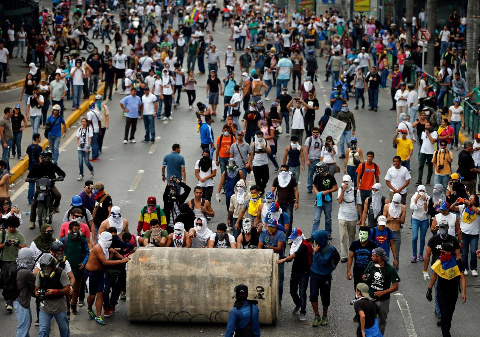Manifestantes ruedan una tubería de agua en un intento por bloquear una autopista durante enfrentamientos con la Guardia Nacional en Caracas, Venezuela, en esta fotografía de archivo del jueves 27 de febrero de 2014. (Foto AP/Fernando Llano)