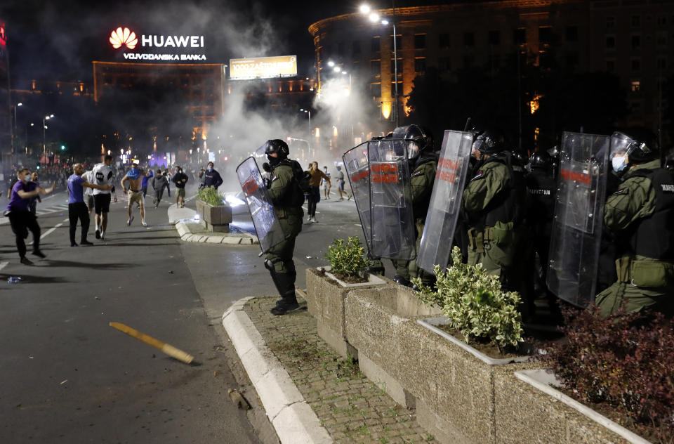 Serbian police officers clash with protesters in front of the Serbian parliament in Belgrade, Serbia, Tuesday, July 7, 2020. Thousands of people protested the Serbian president's announcement that a lockdown will be reintroduced after the Balkan country reported its highest single-day death toll from the coronavirus Tuesday. (AP Photo/Darko Vojinovic)