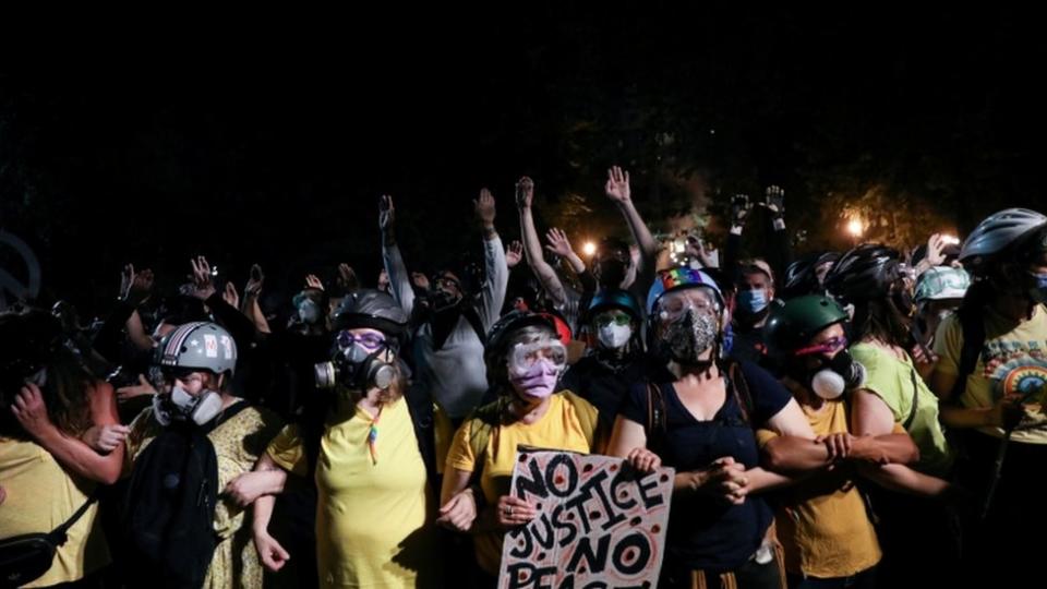 Mothers stand between federal law enforcement officers and protesters during a protest against racial inequality in Portland