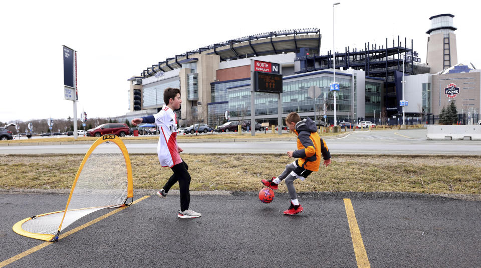 New England Revolution fan Max Steele, 12, left, guards the net as his friend, Leo Riorentini, 8, kicks the ball in the parking lot of Gillette Stadium before an MLS soccer match against Toronto FC, Sunday, March 3, 2024, in Foxborough, Mass. (AP Photo/Mark Stockwell)