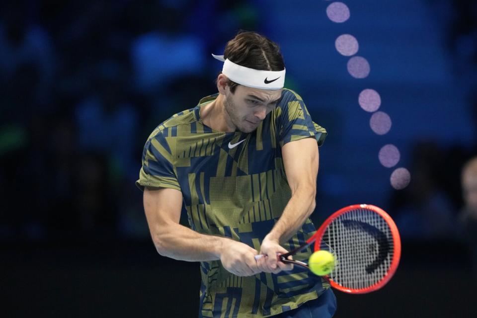 Taylor Fritz returns the ball to Novak Djokovic during their singles semifinal match of the ATP World Tour Finals.