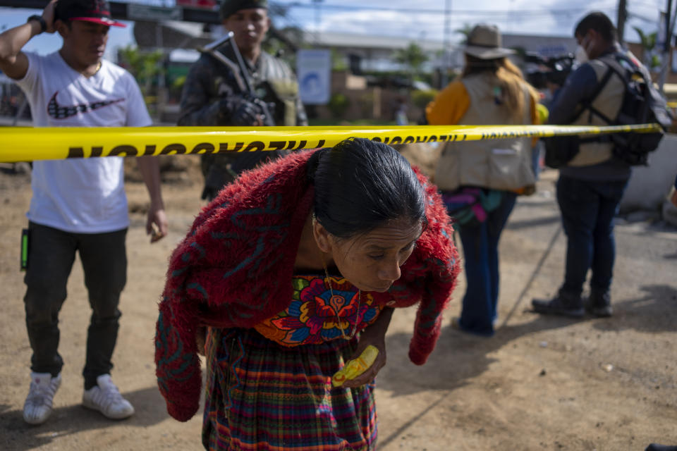 A relative crosses a police line after attending a meeting with a rescue worker, next to a sinkhole in Villa Nueva, Guatemala, Tuesday, Sept. 27, 2022. Search efforts were underway for a mother and daughter who disappeared when their vehicle was swallowed by a massive sinkhole. (AP Photo/Moises Castillo)