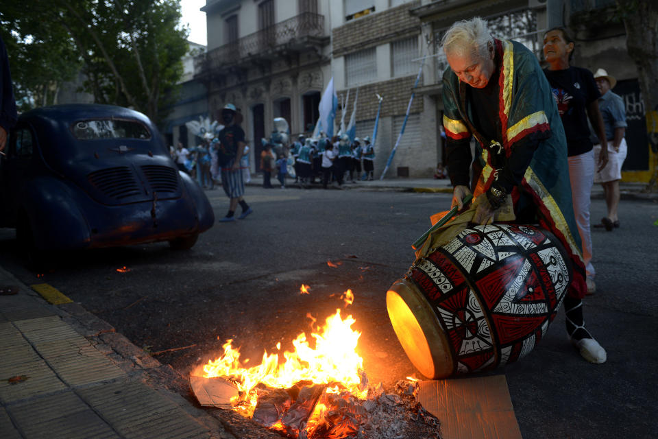CORRECTS PLACE OF DEATH - FILE - In this Feb. 14, 2014 file photo, Uruguayan painter Carlos Paez Vilaro fire-tunes his drum before taking part in Las Llamadas or Calls parade during Carnival celebrations in Montevideo, Uruguay. Paez died Monday Feb. 24, 2014 at his home in Punta Ballena, Uruguay. He was 90 years old. (AP Photo/Matilde Campodonico, File)