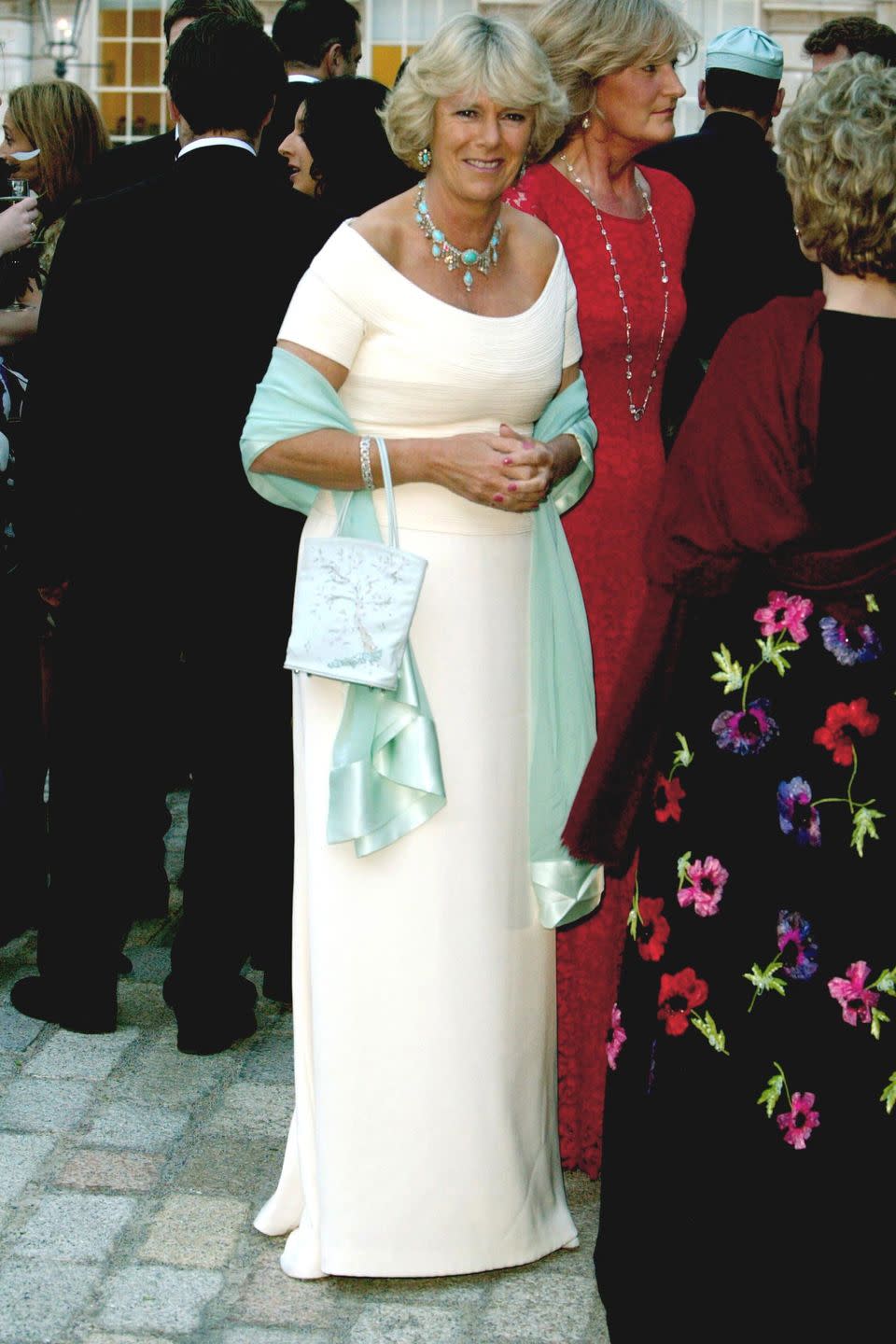 <p>For a summer fete at Somerset House in London, Camilla wore a long, shoulder-sweeping cream dress with pops of turquoise. </p>